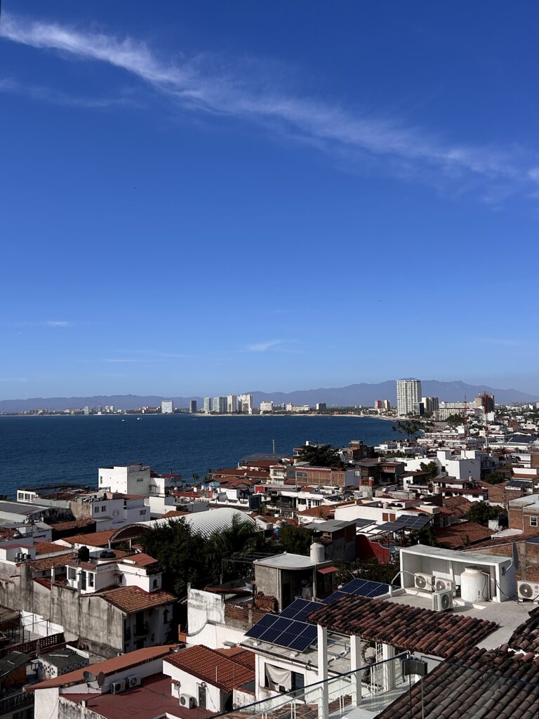 a rooftop view of Puerto Vallarta's old town, and the indigo pacific ocean