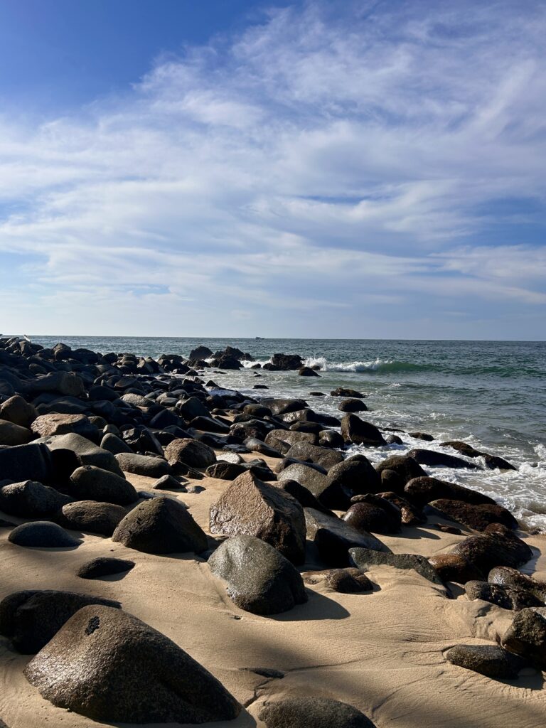 a view of the ocean from a rocky beach