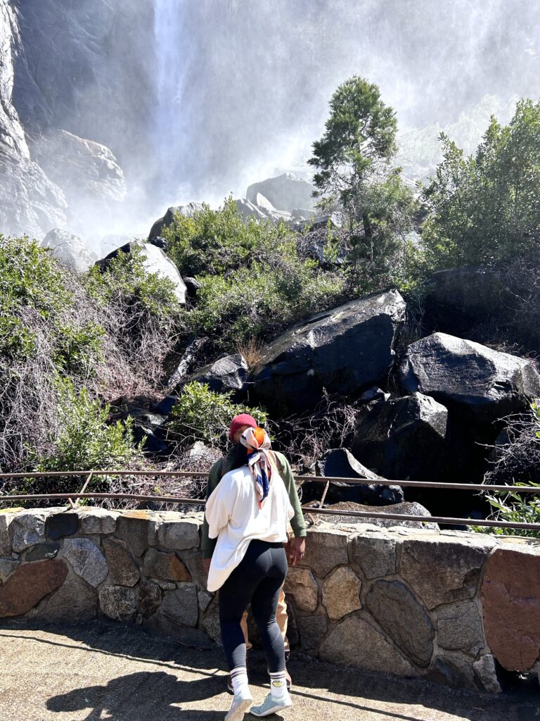 a couple faces each other in front of the misty white cascade of bridal veil falls